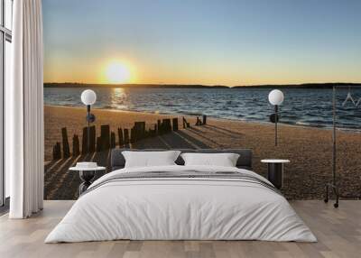 Sunset over Hobart Beach Park with remnants of a wood fence in Northport, Long Island, New York. Wall mural