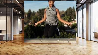 Woman working out on rooftop in suburbs Wall mural