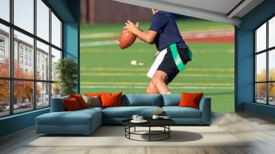 Young athletic boy playing in a flag football game Wall mural