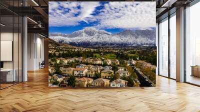 Aerial panorama of snow covered San Gorgonio and Little San Bernardino Mountains on a winter day above Yucaipa Valley with blue sky, white clouds, houses, hills Wall mural