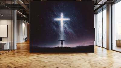 Christian cross symbol in the night sky with silhouette of person with their arms raised worshipping God Wall mural