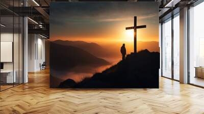 Silhouette of a Christian cross and man on a mountain top with sunset Wall mural