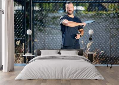 A man plays a deep ball during a pickleball game Wall mural