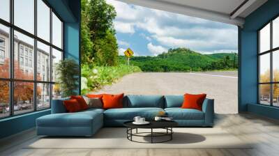 Country road with warning reverse curve left traffic sign. Landscape view of countryside in Thailand. Wall mural