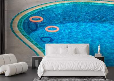 Two orange ring lifebuoys in swimming pool. It is a life saving buoy to prevent people drowning in the water. Wall mural