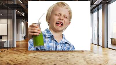 Boy pulling funny face holding green smoothie Wall mural