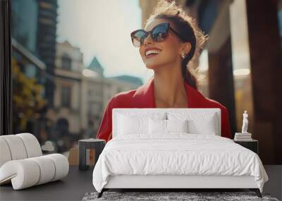 A woman in red and sunglasses is walking down the street with shopping bags, smiling happily as she walks past luxury stores Wall mural