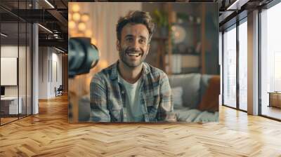 Smiling Man Being Interviewed on Camera. Cheerful man in a casual shirt sitting for an on-camera interview in a cozy room, giving a sense of approachability and openness. Wall mural