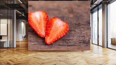 Cut ripe red strawberry on a wooden background. Wall mural