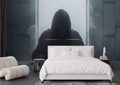 a human in black hoodie using a laptop Wall mural