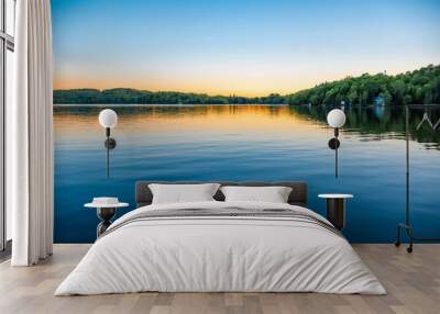 A lake house sits on the shore of the calm water of Peninsula Lake near Huntsville, Ontario on a clear summer evening. Wall mural