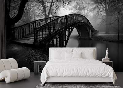 A tranquil scene unfolds as a vintage arch bridge spans over still waters, surrounded by trees shrouded in mist during a quiet evening. Wall mural