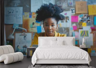 A young black woman in a creative office space, deeply focused on her laptop screen, with sketches and mood boards in the background, business technology, with copy space Wall mural