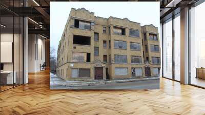 Abandoned and boarded-up yellow brick apartment building in Chicago's Englewood neighborhood in winter Wall mural