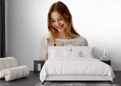 Cellular technology, mobile apps concept. Smiling beautiful woman using smartphone, looking at her phone with happy face, reading, standing over white background Wall mural