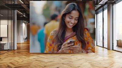 Cheerful multiethnic Indian woman messaging on phone  Wall mural