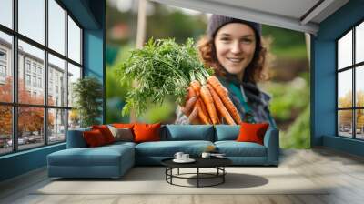 Close up gardener with bunch of carrots in hand in garden Wall mural