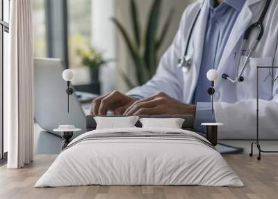 Close up shot of a doctor working intensely on a laptop in his office. Wall mural