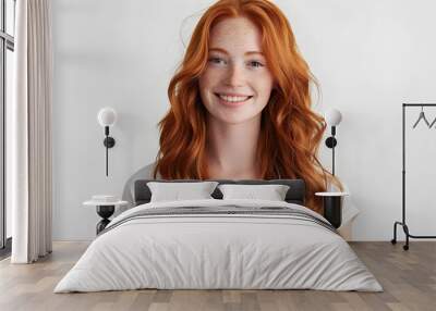 Closeup of happy attractive young woman with long wavy red hair and freckles wears stylish t shirt looks happy and smiling isolated over white background Wall mural