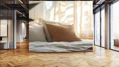 Cropped shot of a king sized bed in a stylish boho bedroom with beams of natural sun light from the window. Kingsize bed with puffy pillows. Close up, copy space, background. Wall mural