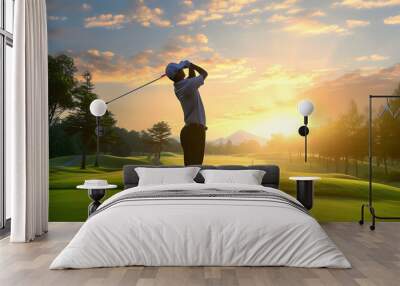 Golfer hit sweeping driver after hitting golf ball down the fairway with sunrise background  Wall mural