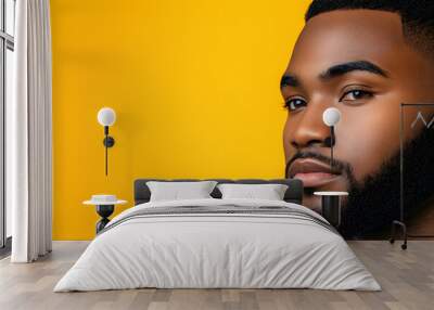 Half face portrait of confident african american man with beard on yellow studio background, free space Wall mural