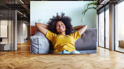 Happy afro american woman relaxing on the sofa at home - Smiling girl enjoying day off lying on the couch - Healthy life style, good vibes people and new home concept Wall mural