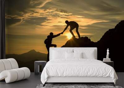 Man is giving helping hand, Silhouettes of people climbing on mountain at sunset, Help and assistance concept, Silhouettes of two people climbing on mountain and helping Wall mural