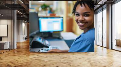 nurse and receptionist at hospital on a computer working at her desk or table in an office as a black woman. Medical, healthcare professional or worker smile, happy and excited at work Wall mural