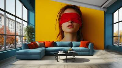 Portrait of a young woman with a red blindfold on yellow background with copy space. Wall mural