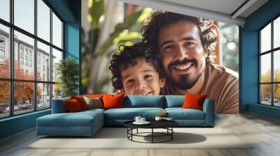 Portrait of cheerful hispanic father and son with curly black hair at home Wall mural