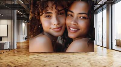 Portrait of happy biracial sisters looking at camera and embracing Wall mural