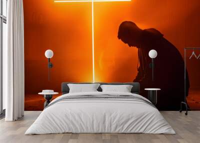 Silhouette of worshiper praying in front of cross symbol made of shining light Wall mural