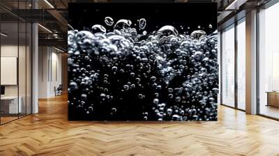 Soda water bubbles splashing underwater against black background. Soda liquid texture that fizzing and floating up to surface like a explosion in under water for refreshing carbonate drink concept. Wall mural