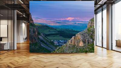 Beautiful view of Galilee from the cliff of Mount Arbel National Park and Nature Reserve, with the snow-capped Mt Hermon lit up by pink sunset light in the distance; Lower Galilee, Israel Wall mural