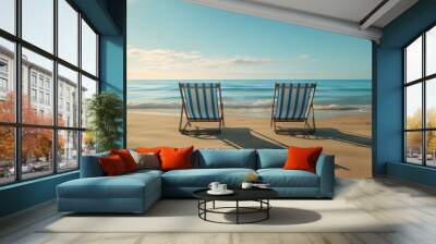 two empty deck chairs set up on a sandy beach in front of the ocean Wall mural