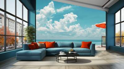 Two outdoor chairs and an umbrella sit on the sandy beach, under the azure sky with fluffy clouds. The view is serene and perfect for a relaxing vacation Wall mural