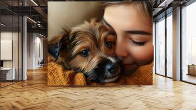 Woman cuddles playful Border Terrier puppy in a cozy home setting with a copy space image opportunity Wall mural