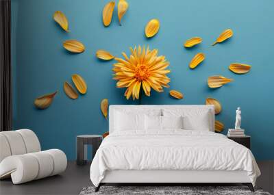 Yellow flower on bright blue background with petals. Emotion concept. Summer flat lay. Wall mural