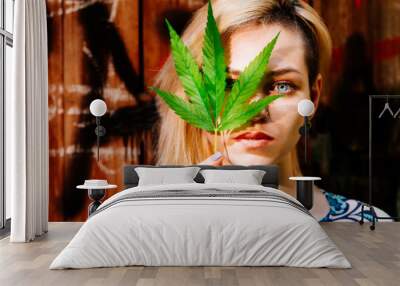 A girl with a cannabis leaf near her face Wall mural