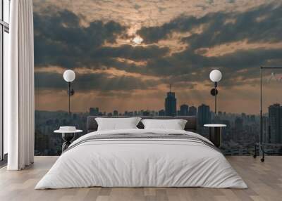 City skyline during sunset with rays of light breaking through clouds. Wall mural