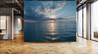 Sunset over the ocean with dramatic clouds and calm waters Wall mural