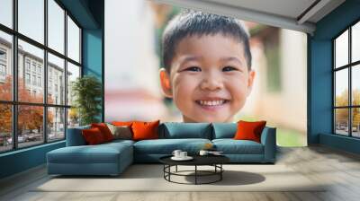 Close up portrait of asian boy smiling in the park. Wall mural