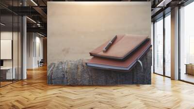 Notebooks,books and pen on the beach. Wall mural