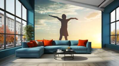 Silhouette of little girl raising hand to freedom happy time Wall mural