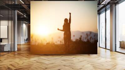 Silhouette of woman praying over beautiful sky background Wall mural