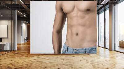 Young handsome fit man posing his muscles isolated on white background with copyspace. Wall mural