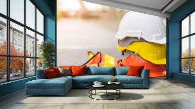 safety first project of workman as engineer or worker or crew and insurance, business concept. construction safety gear including a white, yellow and blue hard safety helmet on concrete floor on city Wall mural