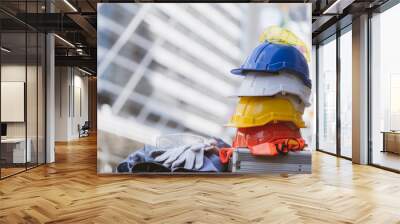 white, yellow and blue hard safety helmet hat for safety project of workman as engineer or worker, on concrete floor in construction site. concept of Banner work safety first, health and protections Wall mural