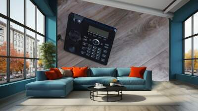 Close Up Black ip phone is placed on a wooden floor in the office. Wall mural